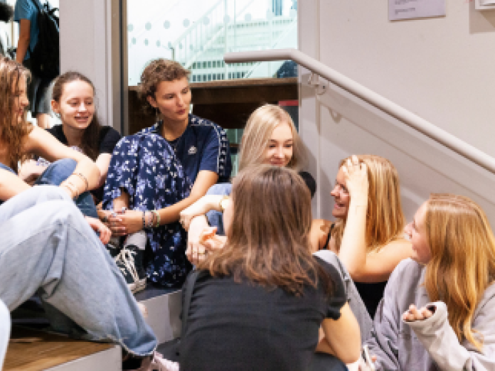 A group of students sitting on auditorium steps