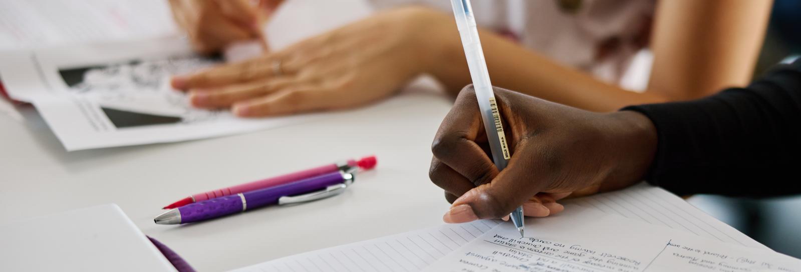 Student writing notes on paper